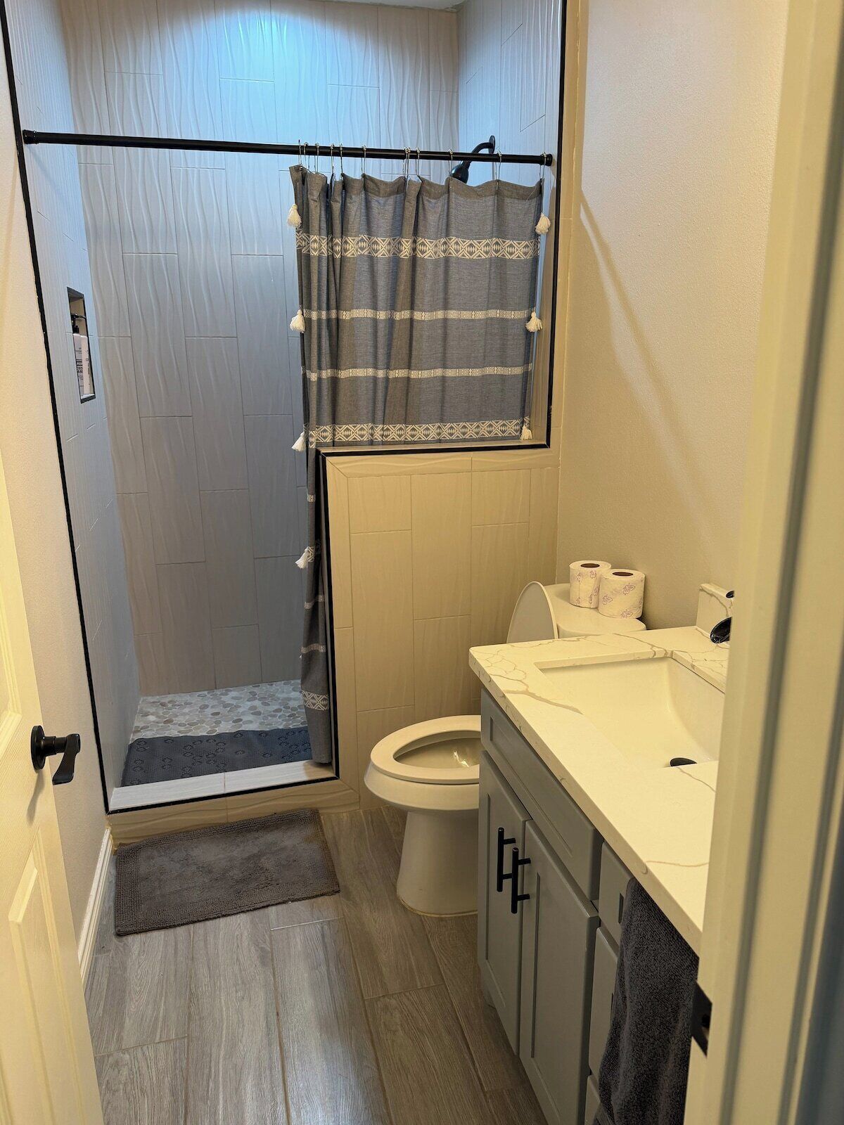 A bathroom with a shower, toilet, and sink.