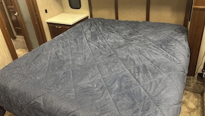 Une chambre à coucher de taille réduite, avec un lit, une petite table de chevet et une fenêtre.
