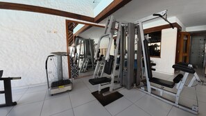 A gym with various exercise equipment, including a treadmill, weight machines, and a bench. - Gran Hotel Santa Cruz  (Santa Cruz)