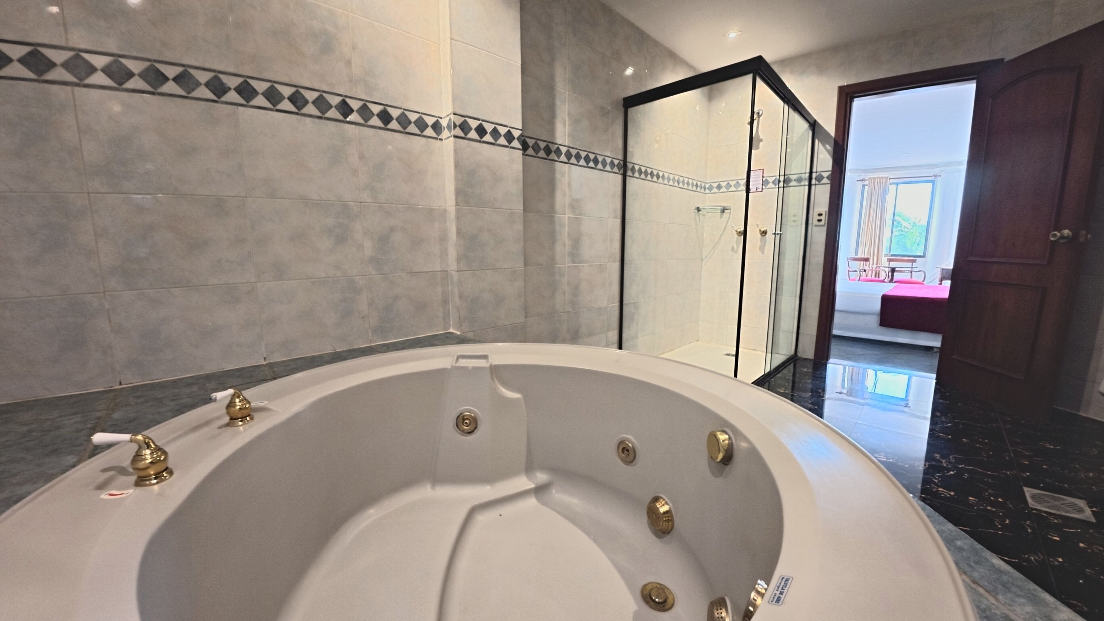 A modern bathroom with a freestanding bathtub, a glass-enclosed shower, and a marble floor.