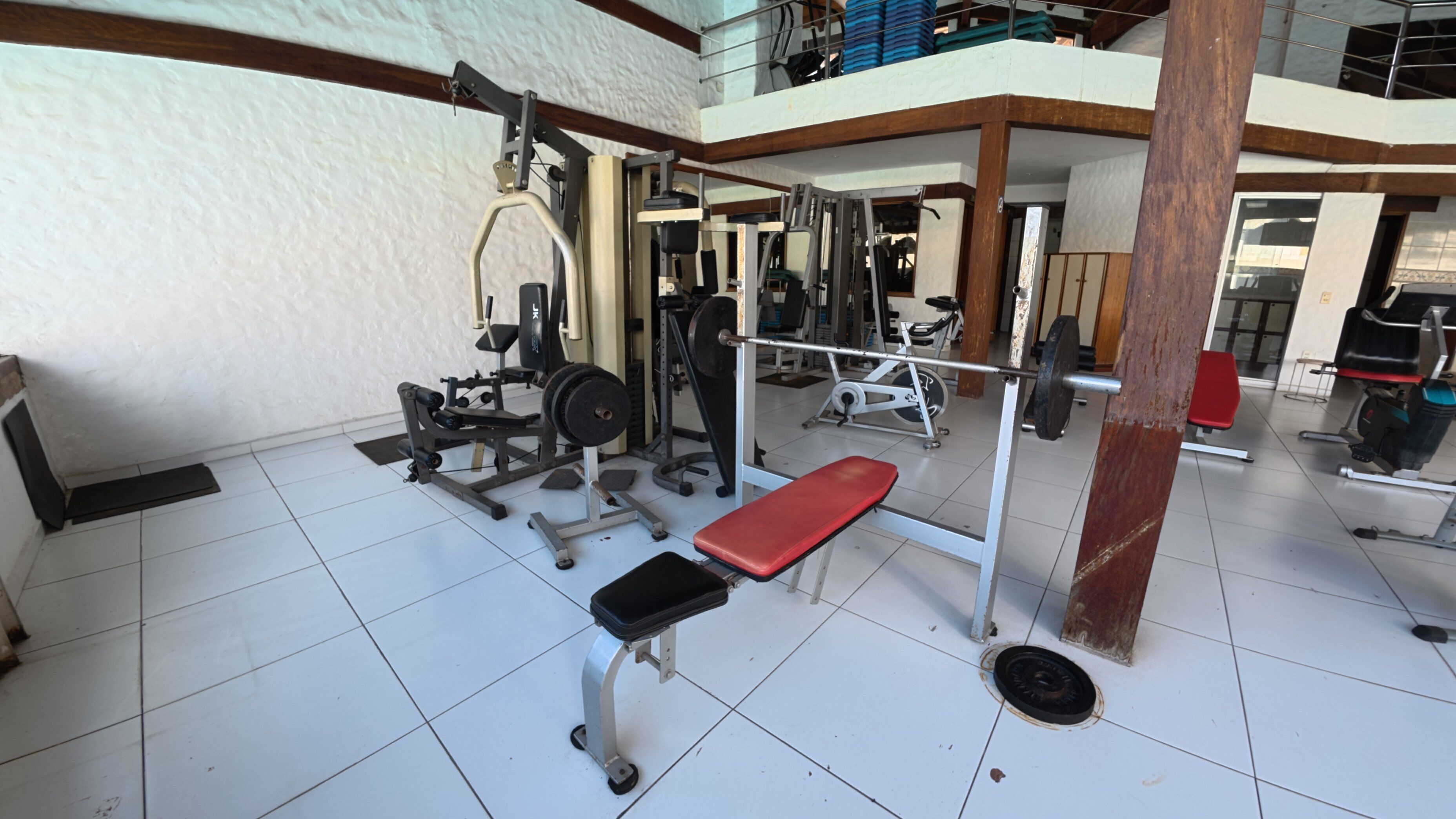 A gym with various exercise equipment, including a bench press and weight machines.