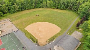 Um campo de beisebol rodeado por uma floresta densa.