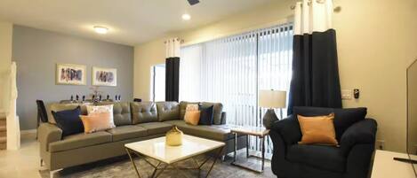 A living room with a sofa, coffee table, and a ceiling fan.