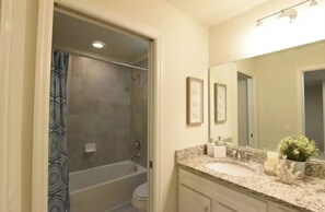 A bathroom with a shower, toilet, sink, and mirror. - SuperHero's 5-bedroom home in marvelous Orlando with Pool (Kissimmee)