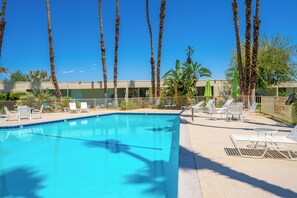 A swimming pool with lounge chairs and palm trees. - Seven Lakes Golf and Country Club 2 bedroom plus Den bungalow (Palm Springs)
