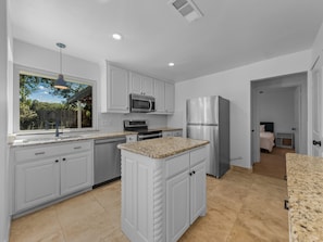 A modern kitchen with white cabinetry, stainless steel appliances, and a granite countertop. - 5-bedroom 4 bath Pool  house near AT&T Stadium Arlington (Arlington)