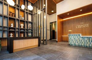 A reception area with a wooden reception desk, a checkered counter, and a wall with the name 'THE CROSBY'. - The Crosby Balcony Studio Miami Worldcenter (Miami)