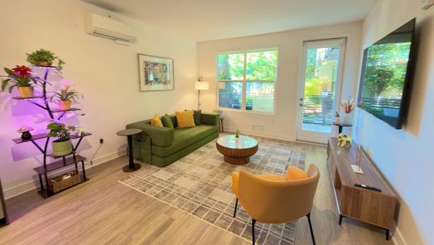 A living room with a green sofa, a small round table, a yellow chair, a floor lamp, and a wall-mounted TV. - Entire place: Apto in Menlo Park, CA, USA (Menlo Park)