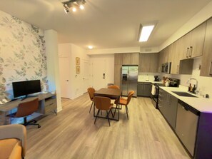 A modern kitchen with wooden cabinets, a stainless steel refrigerator, and a microwave. - Modern, 1-bedroom, near Stanford and Meta, with parking. (Menlo Park)
