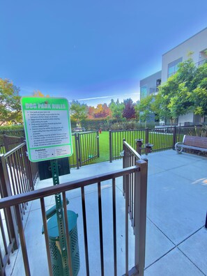 A dog park with a sign detailing rules and a fenced area. - Modern, 1-bedroom, near Stanford and Meta, with parking. (Menlo Park)