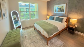 A bedroom with a bed, bedside lamps, a mirror, a green chair, a window, and a painting on the wall. - Entire place: Apto in Menlo Park, CA, USA (Menlo Park)