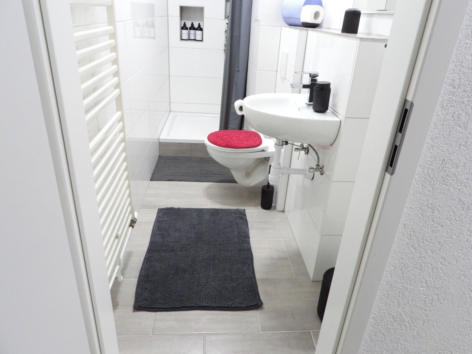 Ein Badezimmer mit Toilette, Waschbecken und Duschbereich.
