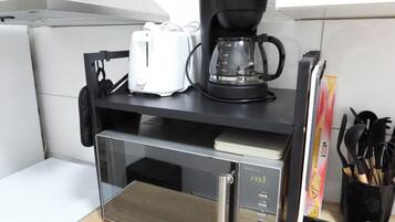 Eine Küche mit Mikrowelle, Kaffeemaschine und Toaster.
