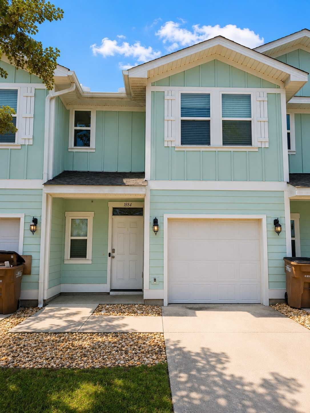 A two-story house with a garage, a front door, and a small window.