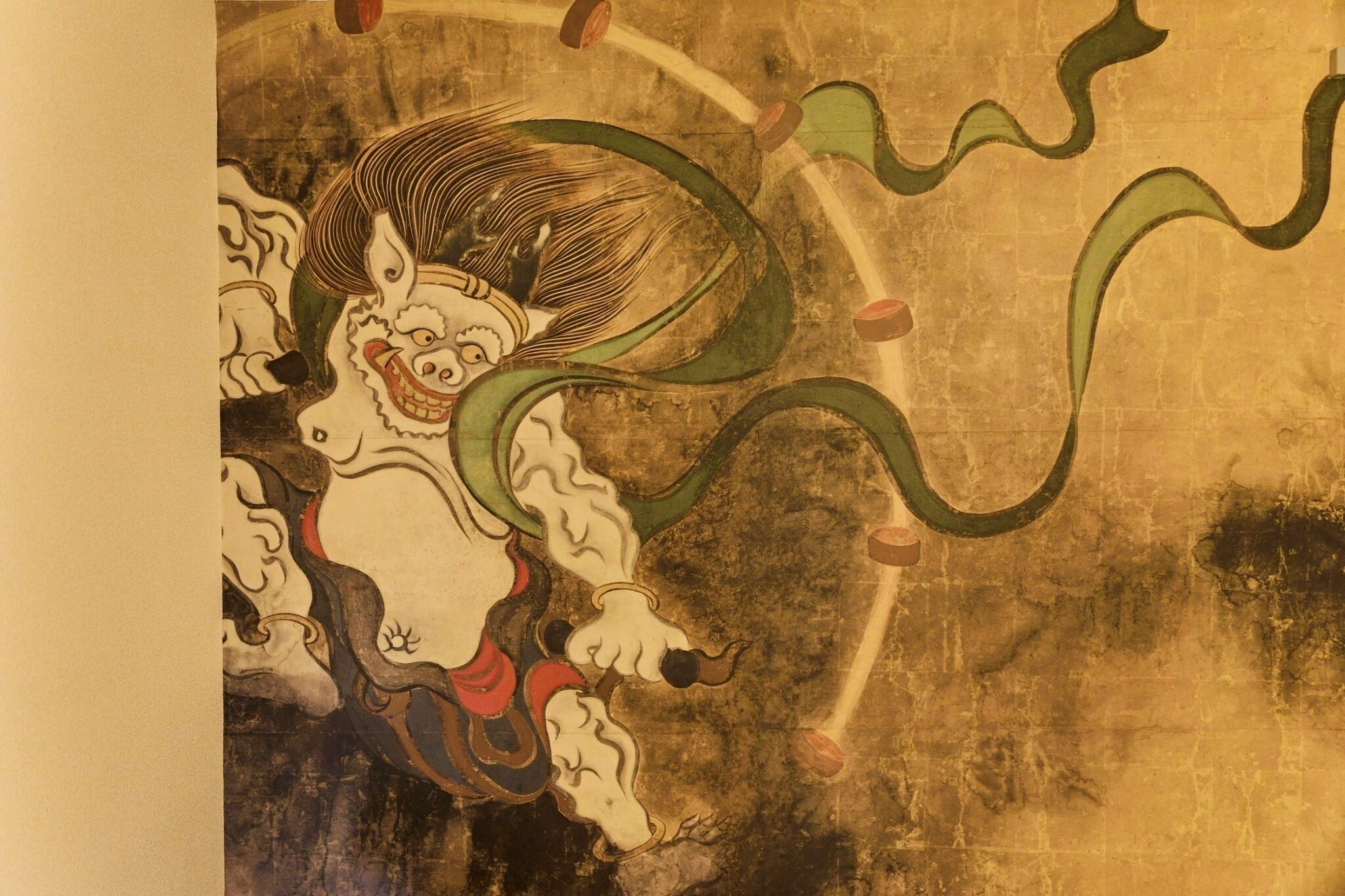 A traditional Japanese artwork with a central figure surrounded by abstract patterns.