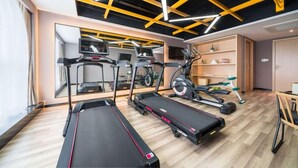 A gym with treadmills, elliptical machines, and a mirrored wall. - Atour Hotel (Changsha)