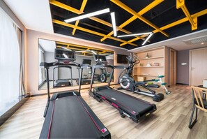A gym with treadmills, elliptical machines, and a mirrored wall. - Atour Hotel (Changsha)