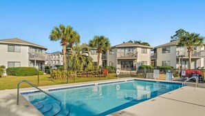 A swimming pool with a clear blue water surface, surrounded by a concrete deck. - Modern Retreat - Pool  - Walk to Beach (Miramar Beach)