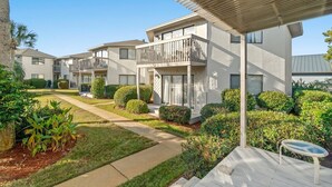 A residential building with multiple balconies, a covered patio, and well-maintained landscaping. - Modern Retreat - Pool  - Walk to Beach (Miramar Beach)