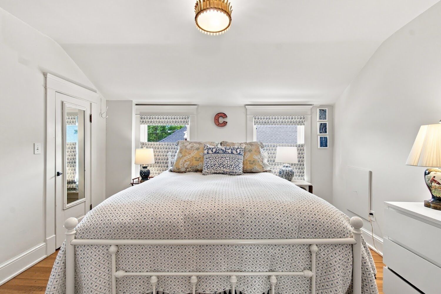 A bedroom with a bed, bedside tables, a lamp, and a window with curtains.