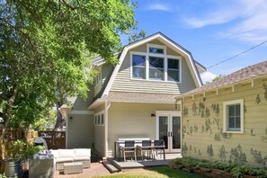 A two-story house with a covered patio, a dining area, and a garage. - Historic Mapleton Hill Home with Victorian Charm and Modern Amenities (Boulder)