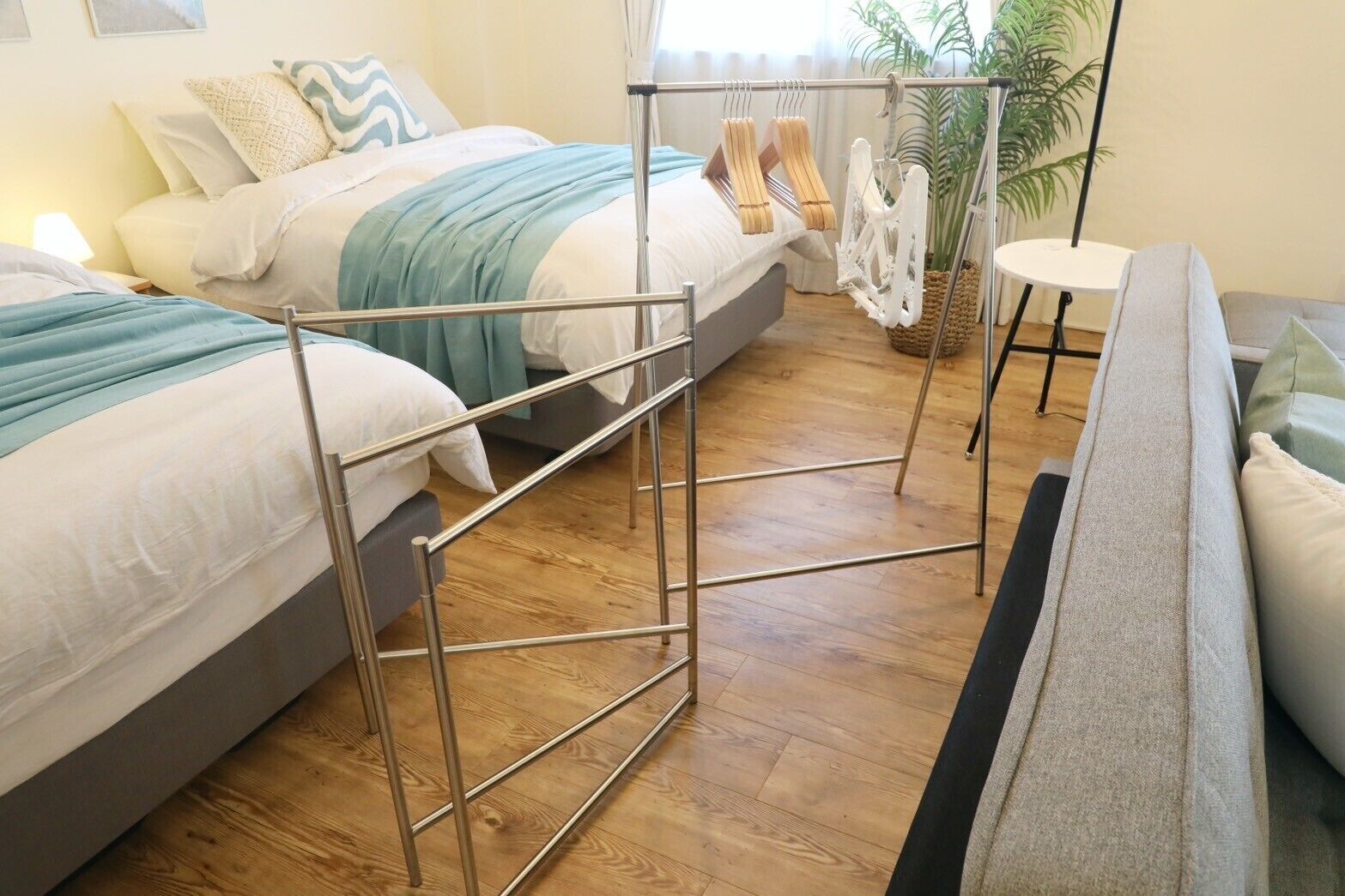 Une chambre d’hôtel avec deux lits, un canapé, une petite table et une plante.