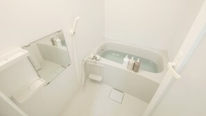 Un bagno con vasca, doccia e specchio.