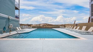 En rektangulær swimmingpool med 3,6 meters dybde, omgivet af liggestole og en beton terrasse.