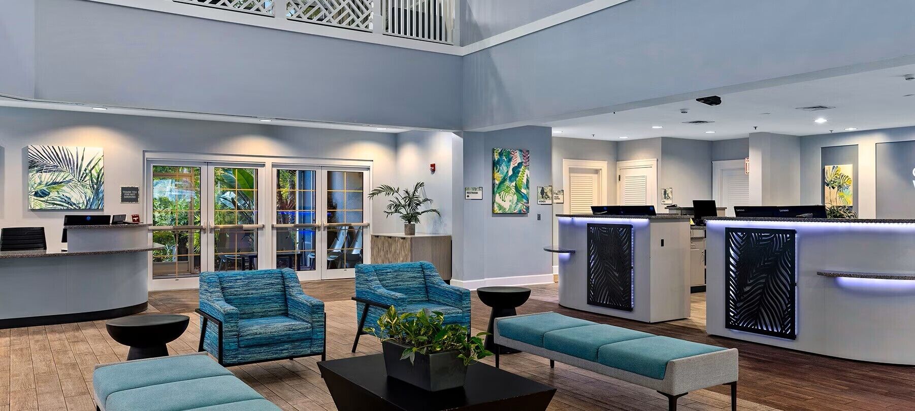 A modern lobby with seating, a reception desk, and artwork on the walls.