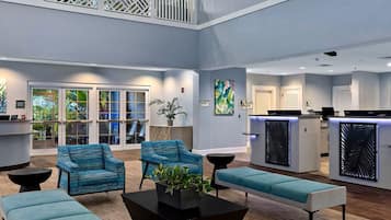 A modern lobby with seating, a reception desk, and artwork on the walls.