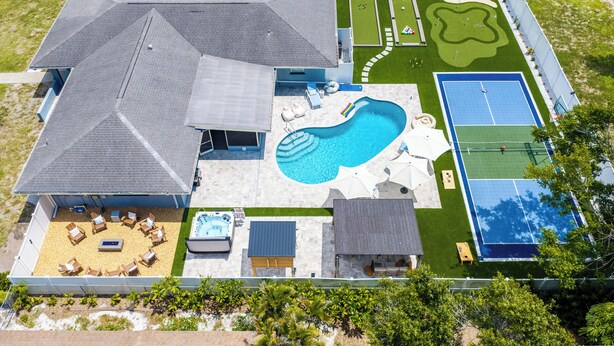 A residential property with a swimming pool, tennis court, and a landscaped lawn. - Full Gym ● 7min to IMG / 16min to AMI ● Sauna & Cold Plunge ● Sport Court ● Pool (Bradenton)