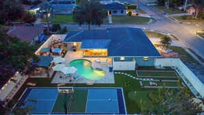 A residential property with a swimming pool, tennis courts, and a covered patio area. - Full Gym ● 7min to IMG / 16min to AMI ● Sauna & Cold Plunge ● Sport Court ● Pool (Bradenton)