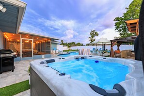 Ein Garten mit Whirlpool, Schwimmbad und Gartenmöbeln.