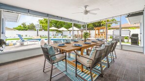 A covered patio with a pool, dining table, chairs, and a ceiling fan. - Full Gym ● 7min to IMG / 16min to AMI ● Sauna & Cold Plunge ● Sport Court ● Pool (Bradenton)
