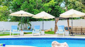 A pool area with lounge chairs and umbrellas. - Full Gym ● 7min to IMG / 16min to AMI ● Sauna & Cold Plunge ● Sport Court ● Pool (Bradenton)