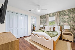 A bedroom with a bed, a nightstand, a television, a ceiling fan, and a door. - Full Gym ● 7min to IMG / 16min to AMI ● Sauna & Cold Plunge ● Sport Court ● Pool (Bradenton)