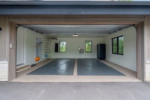 Eine Garage mit zwei Matten am Boden, einer Leiter und einem Lautsprecher.