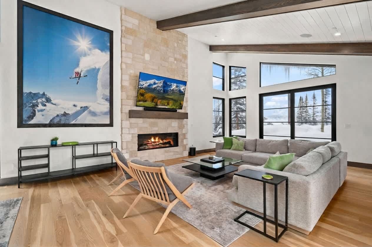 Una sala de estar moderna con chimenea, televisor grande y sofá.