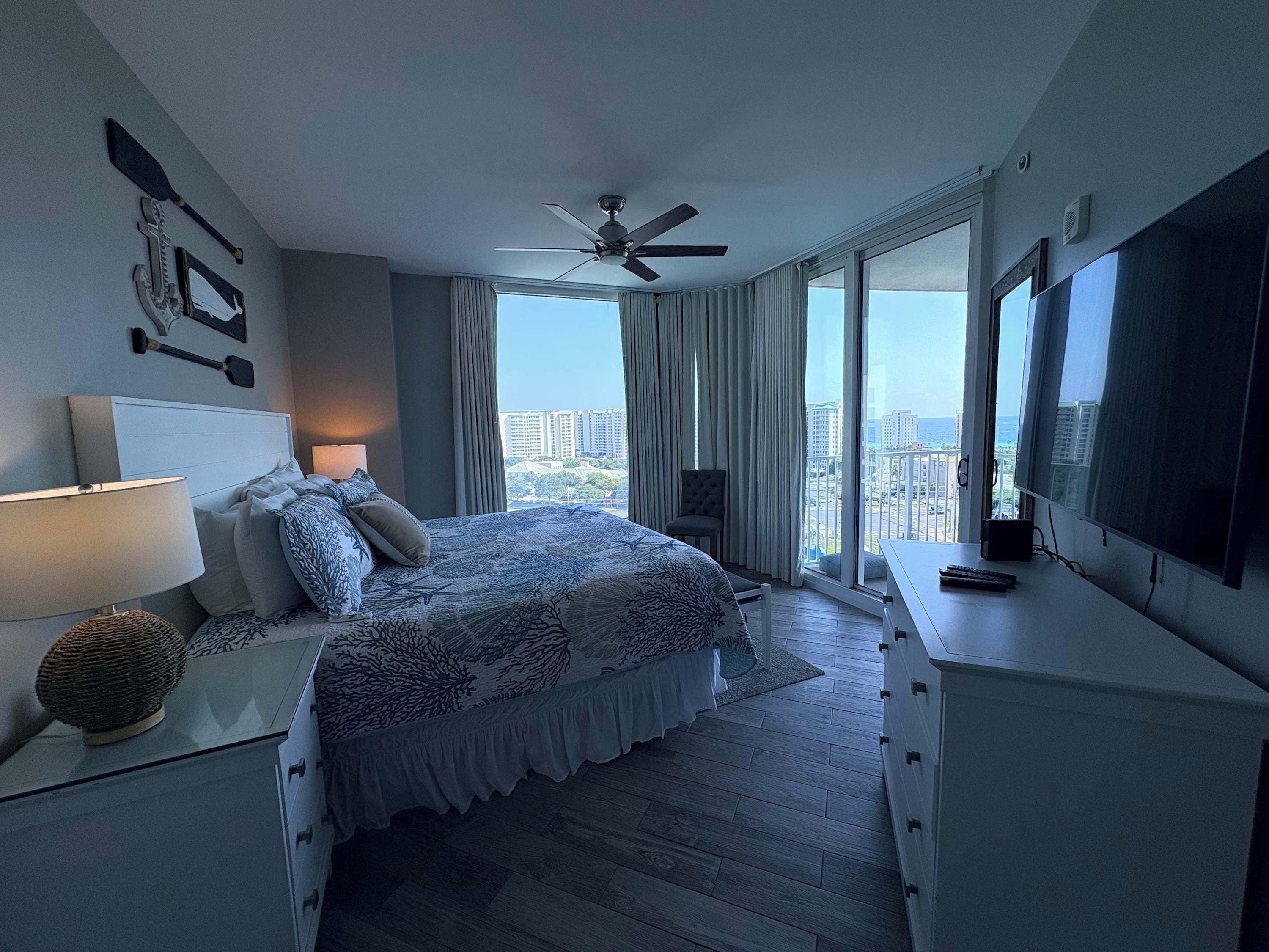 Une chambre moderne équipée d’un lit, d’un bureau, d’une télévision et offrant une vue sur la ville.