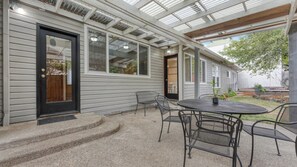 A covered patio with a table and chairs, a door, and a window. - Walk-to-UO Retreat with Private Patio (Eugene)