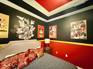 A bedroom with a bed, a nightstand, and wall art featuring cartoon characters. - [LaborDaySpecial] Mario/DisneyThemed 5Br4Ba+Pool BBQ LazyRiver (Kissimmee)