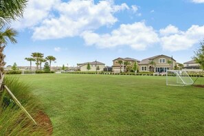 Een woonwijk met huizen, een verzorgd gazon en een voetbalkooi.