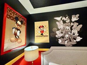 A room with a large framed Louis Vuitton artwork, a lamp, and a wall with a cartoon character mural. - [LaborDaySpecial] Mario/DisneyThemed 5Br4Ba+Pool BBQ LazyRiver (Kissimmee)