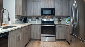 Eine moderne Küche mit Edelstahlgeräten, einer Mikrowelle, einem Backofen und einem Kühlschrank.