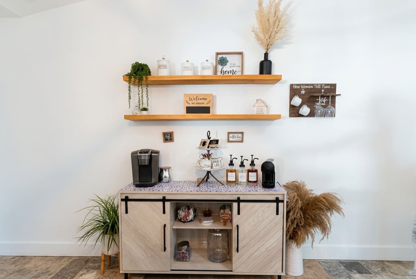 A coffee station with a coffee machine, sugar, tea, and a welcome sign.