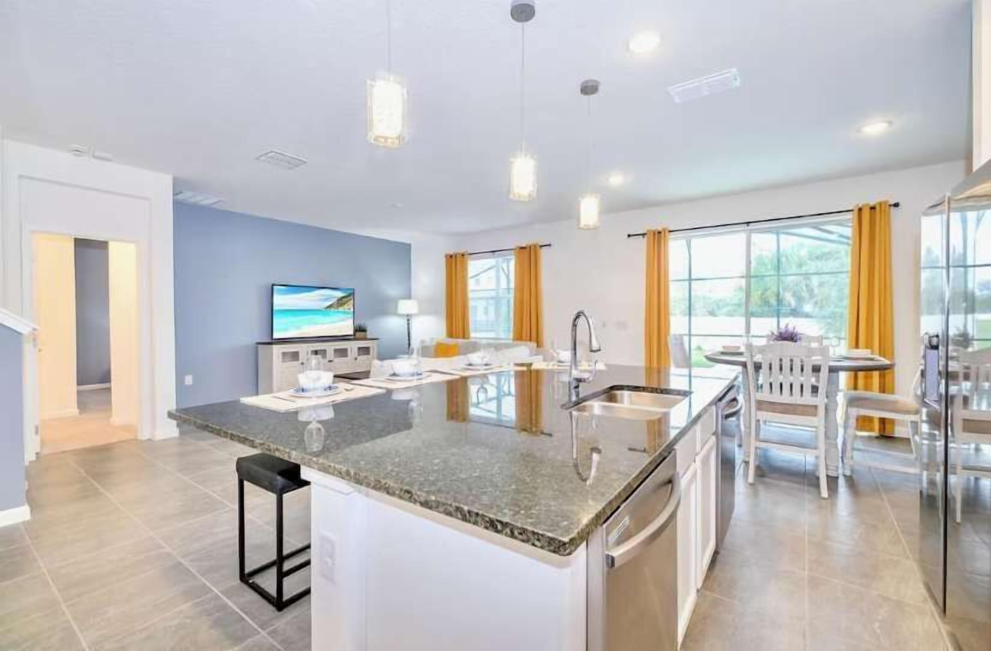 A modern kitchen with a central island, built-in appliances, and a dining area with a table and chairs.