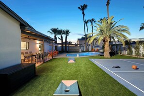 A backyard with a pool, a bocce court, and a dining area with outdoor seating. - Cactus Palms -Pool-Pickleball-Sports Court-Games (Scottsdale)