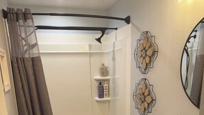 Ein Badezimmer mit Dusche, Toilette, Waschtisch und Spiegel.