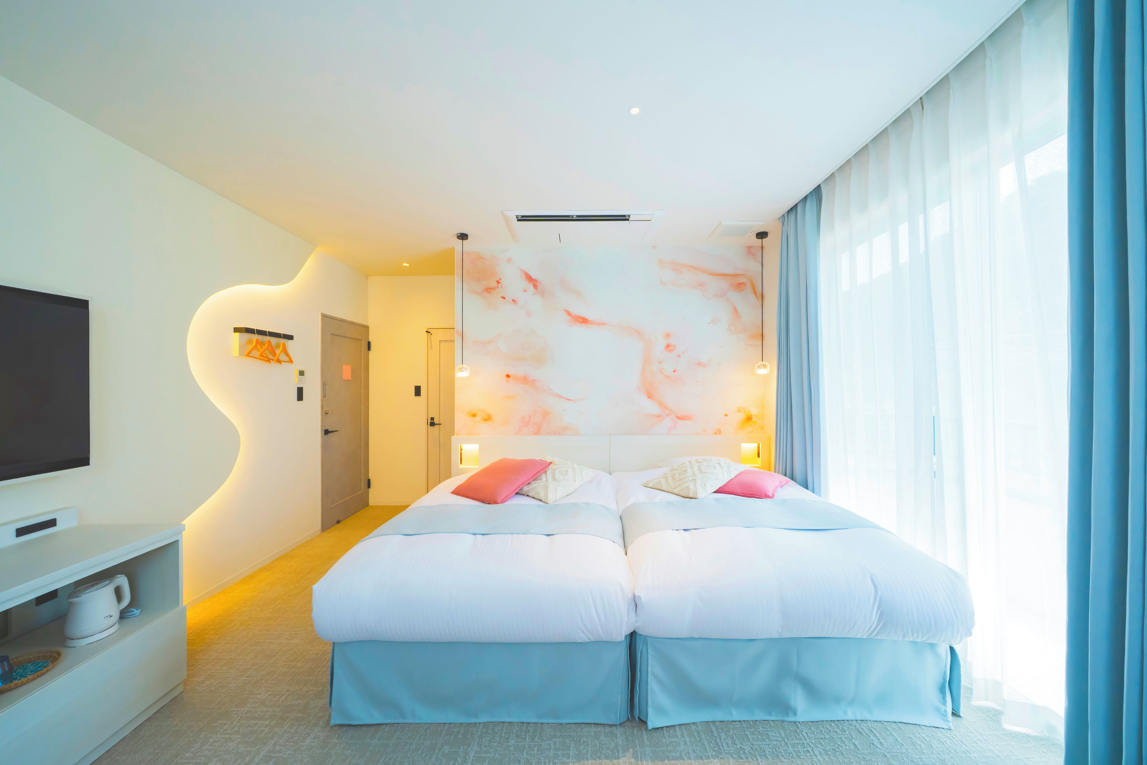 Una habitación de hotel moderna con una cama grande, un televisor de pantalla plana y una pared con diseño de mármol.