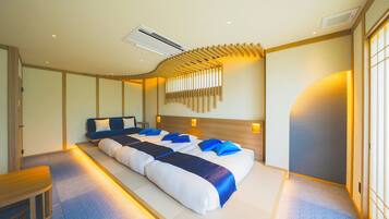 A hotel room with a large bed, a desk, and a wall-mounted air conditioning unit.